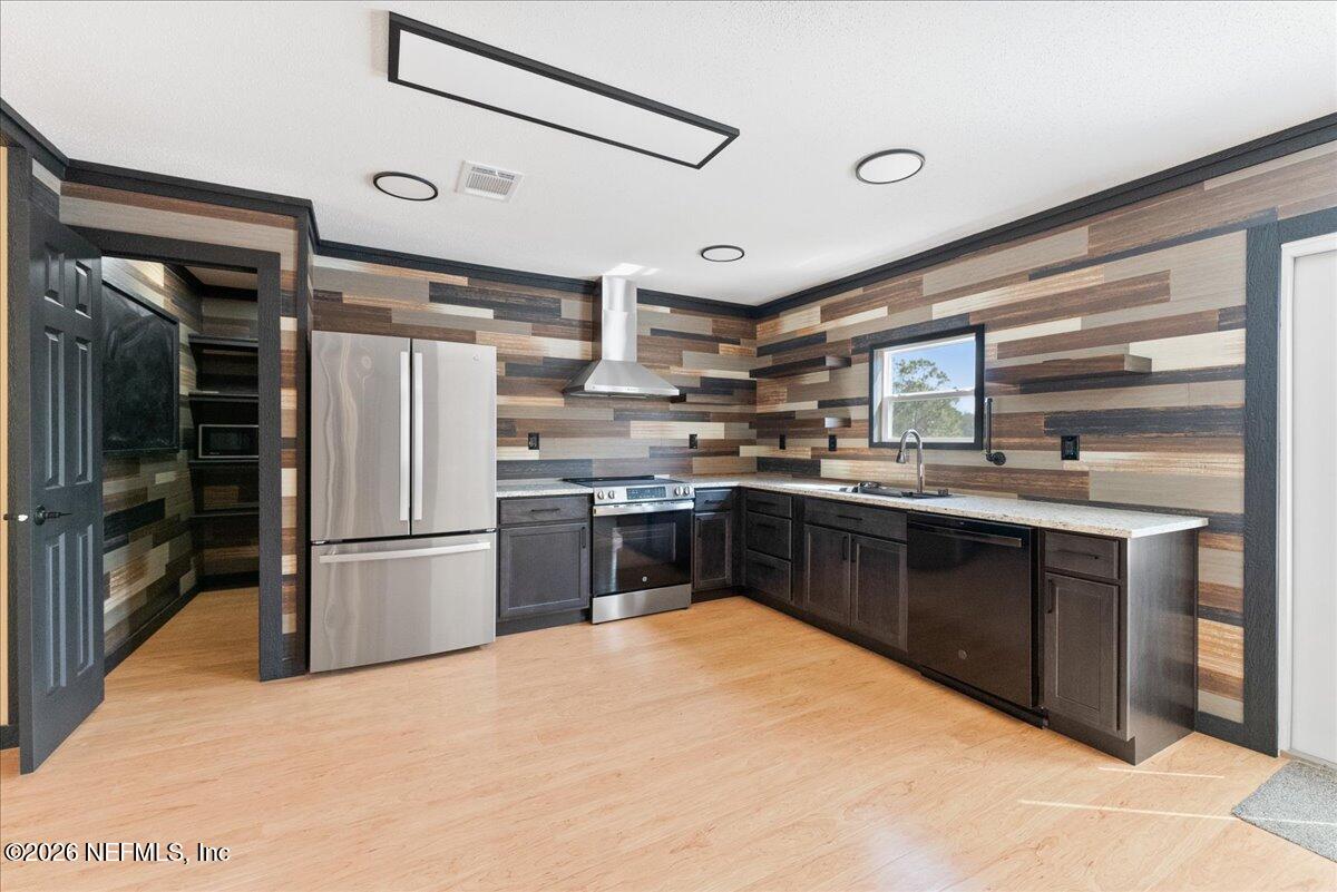 5533 Coronado Street Keystone Heights, FL 32656 - Photo 23 of 73 a kitchen with stainless steel appliances a refrigerator a stove a sink and a refrigerator