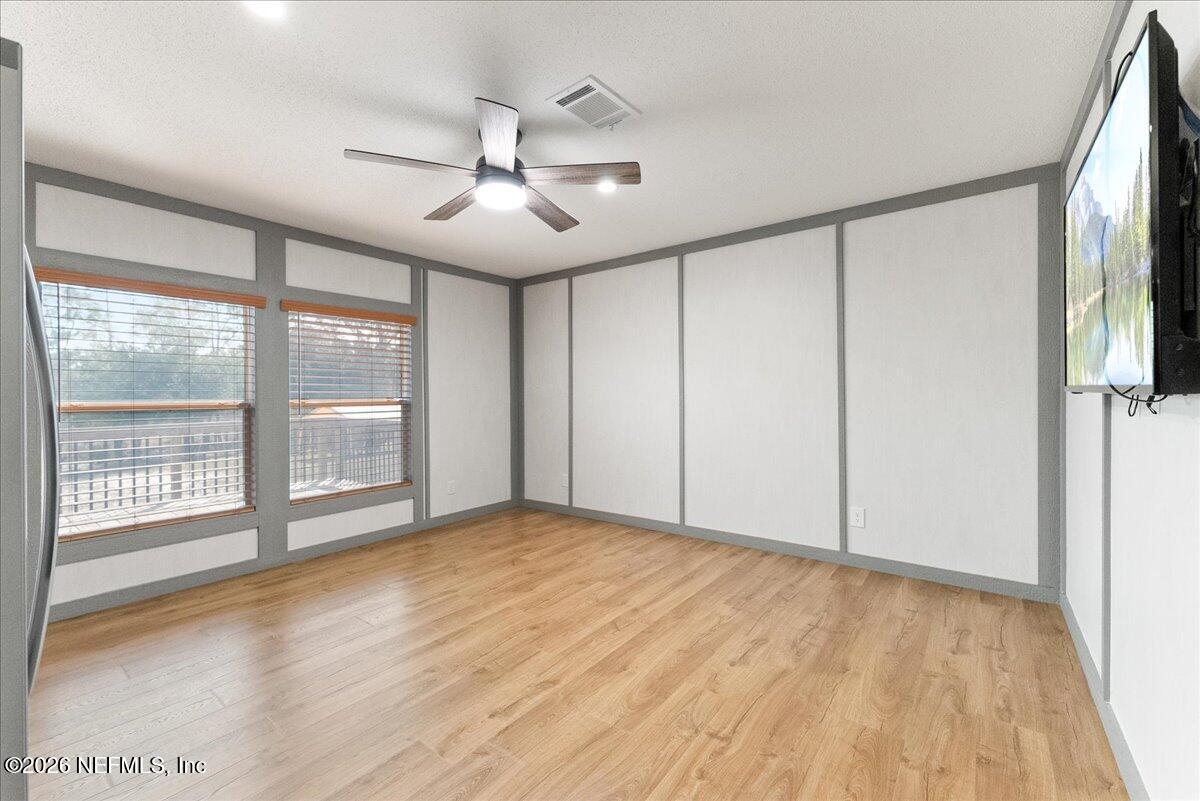 5533 Coronado Street Keystone Heights, FL 32656 - Photo 32 of 73 a view of an empty room with a window and wooden floor