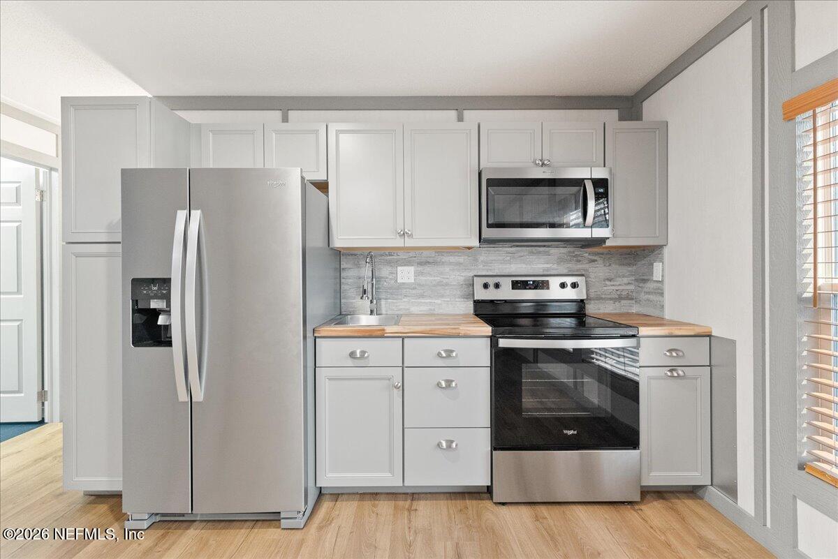 5533 Coronado Street Keystone Heights, FL 32656 - Photo 35 of 73 a kitchen with cabinets stainless steel appliances and a window