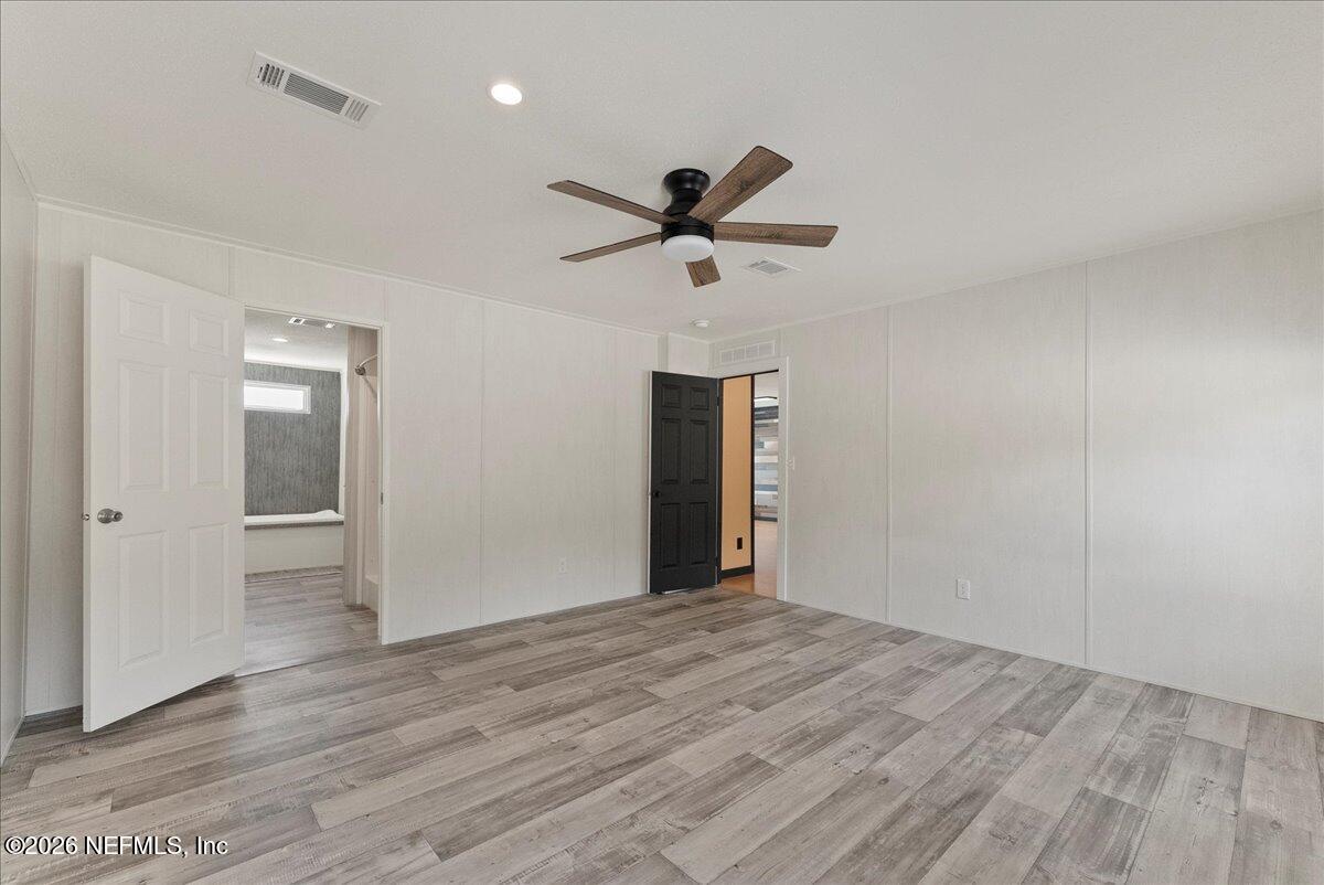 5533 Coronado Street Keystone Heights, FL 32656 - Photo 48 of 73 a view of a big room with wooden floor and a ceiling fan