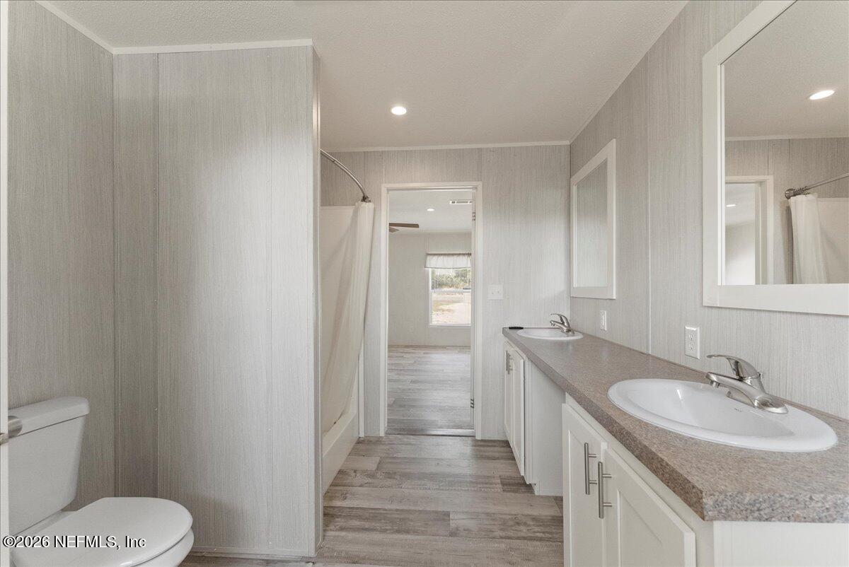 5533 Coronado Street Keystone Heights, FL 32656 - Photo 49 of 73 a bathroom with a granite countertop sink a toilet a shower and a mirror