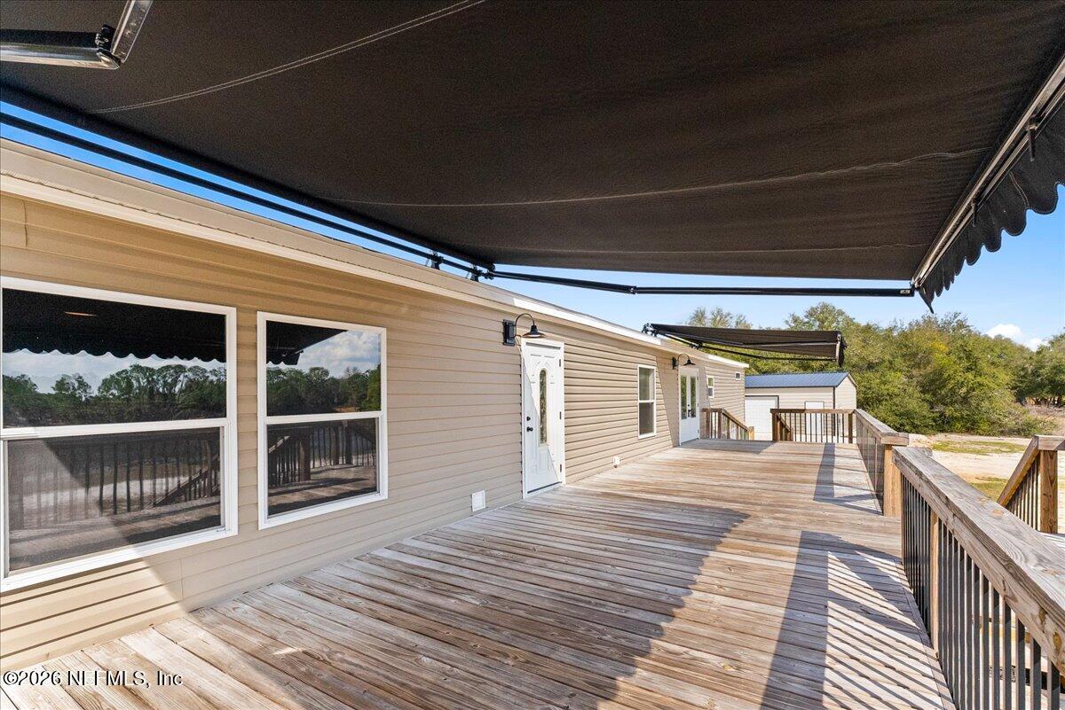 5533 Coronado Street Keystone Heights, FL 32656 - Photo 10 of 73 a porch with wooden floor and yard in the back