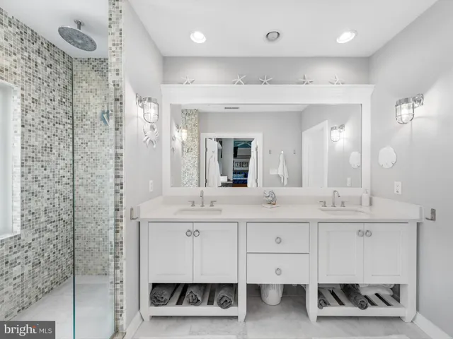 a en suite bathroom with a sink double vanity and a mirror