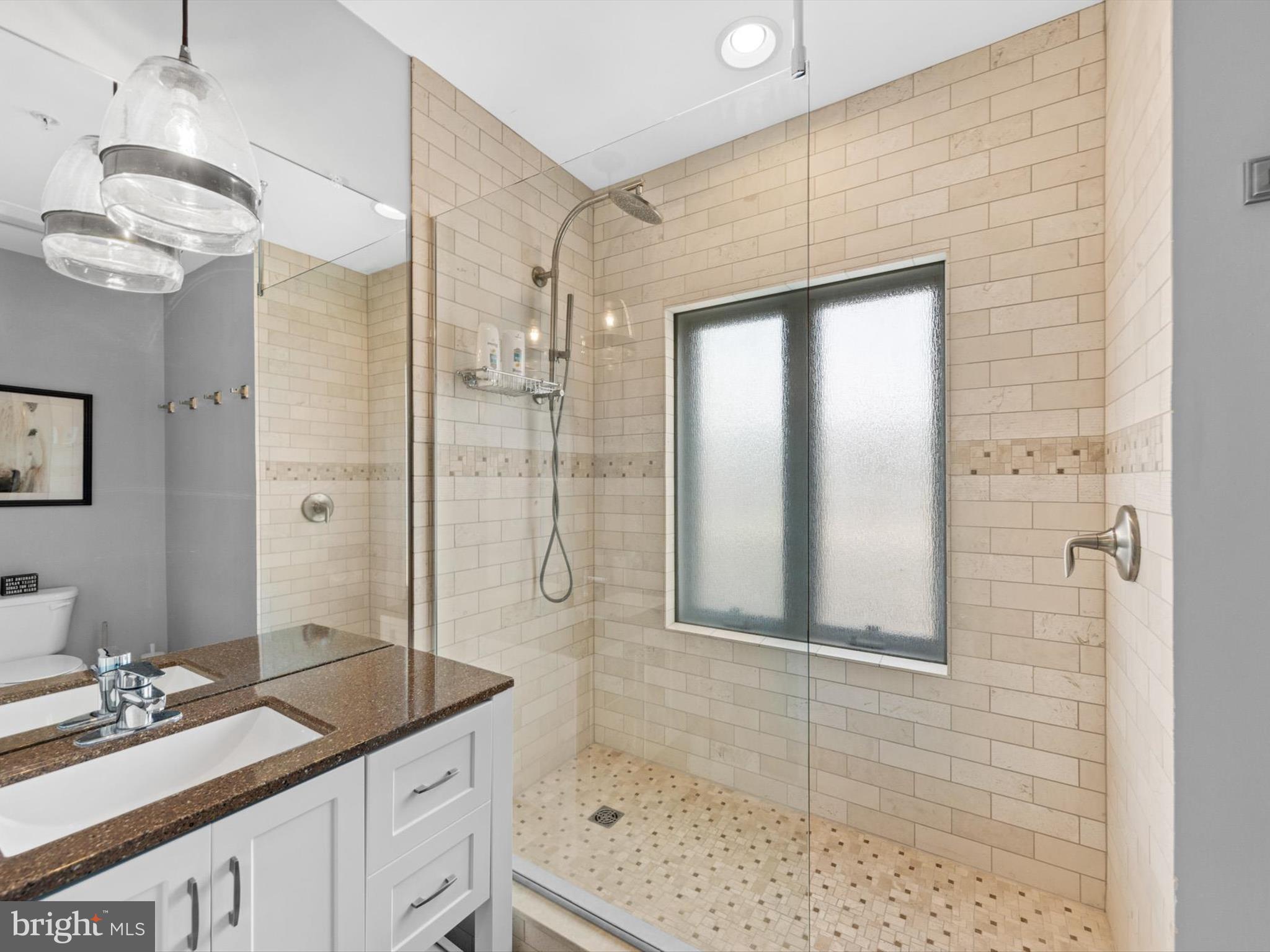 5 87th Street, Unit 303 Ocean City, MD 21842 - Photo 30 of 49 a bathroom with a granite countertop sink a mirror and shower