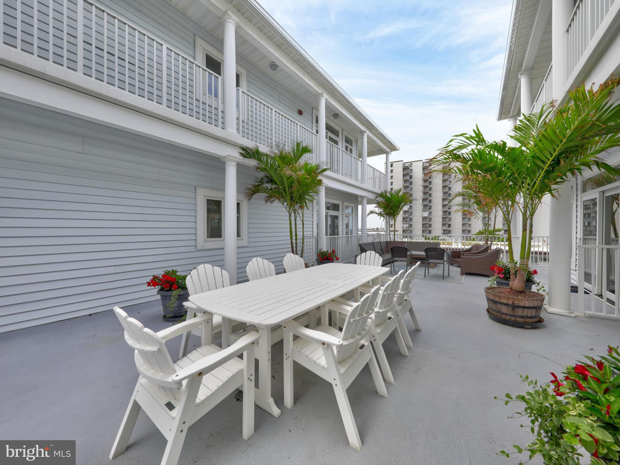 5 87th Street, Unit 303 Ocean City, MD 21842 - Photo 42 of 49 a view of a patio with table and chairs and potted plants