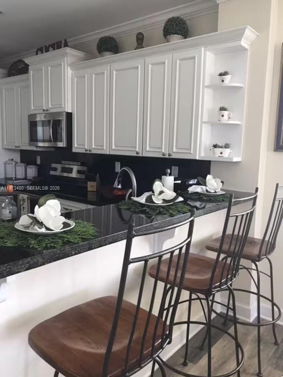 227 Sombrero Beach Road Marathon, FL 33050 - Photo 32 of 56 a kitchen with a chair a stove a table and chairs