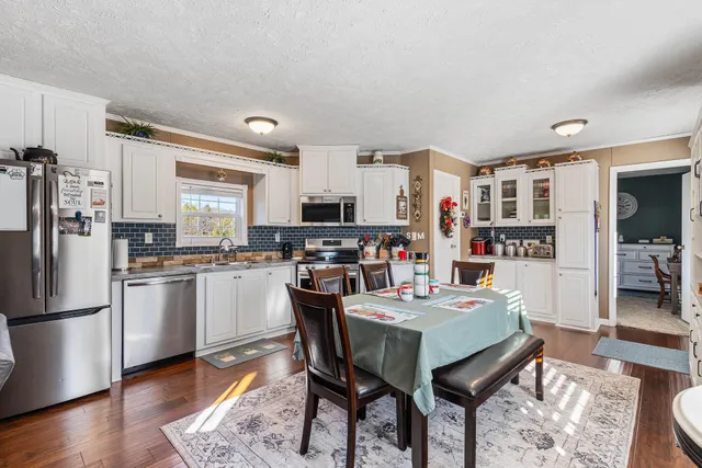 a kitchen with stainless steel appliances a refrigerator a stove a sink dishwasher and a refrigerator with wooden floor