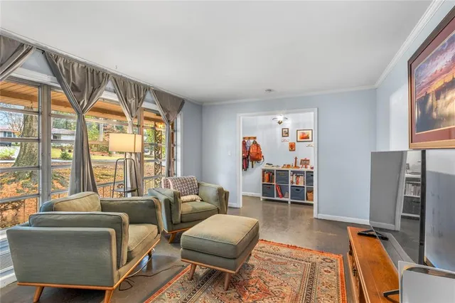 a living room with furniture a flat screen tv and a large window