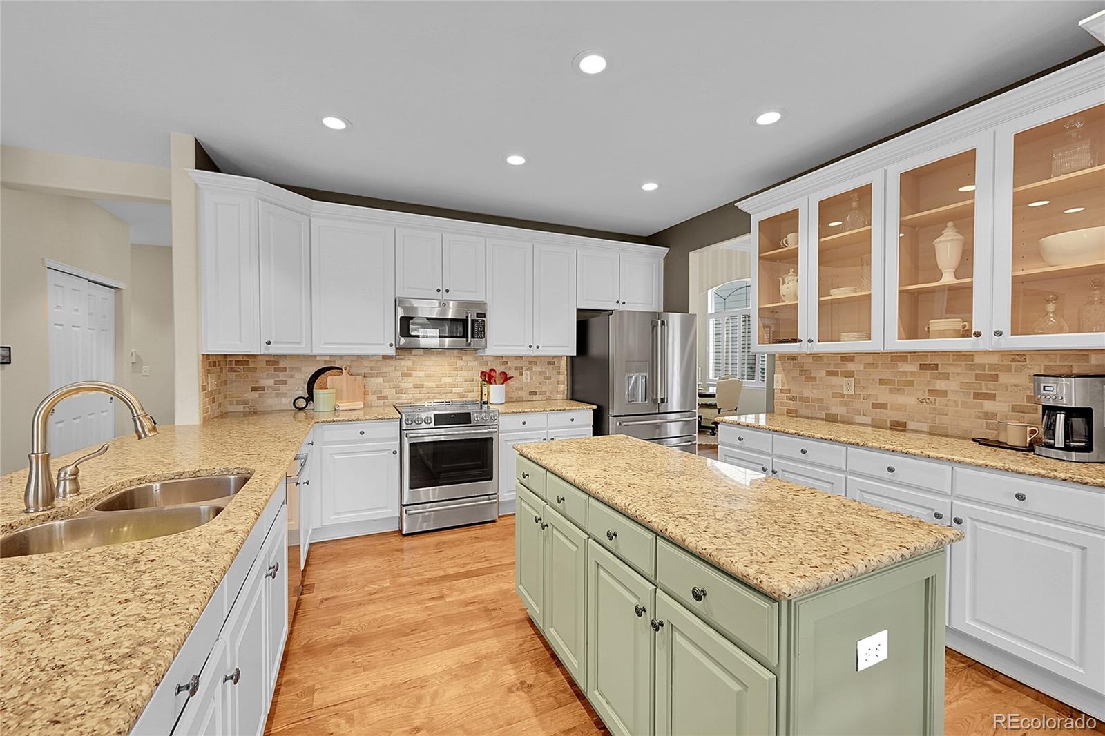 9424 South Hackberry Lane Highlands Ranch, CO 80129 - Photo 13 of 47 a kitchen with a stove a sink a kitchen island and stainless steel appliances