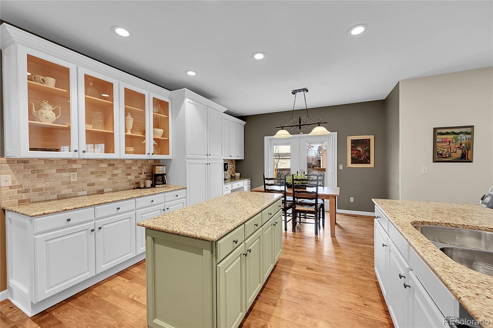 9424 South Hackberry Lane Highlands Ranch, CO 80129 - Photo 14 of 47 a large kitchen with kitchen island a sink a counter space and stainless steel appliances
