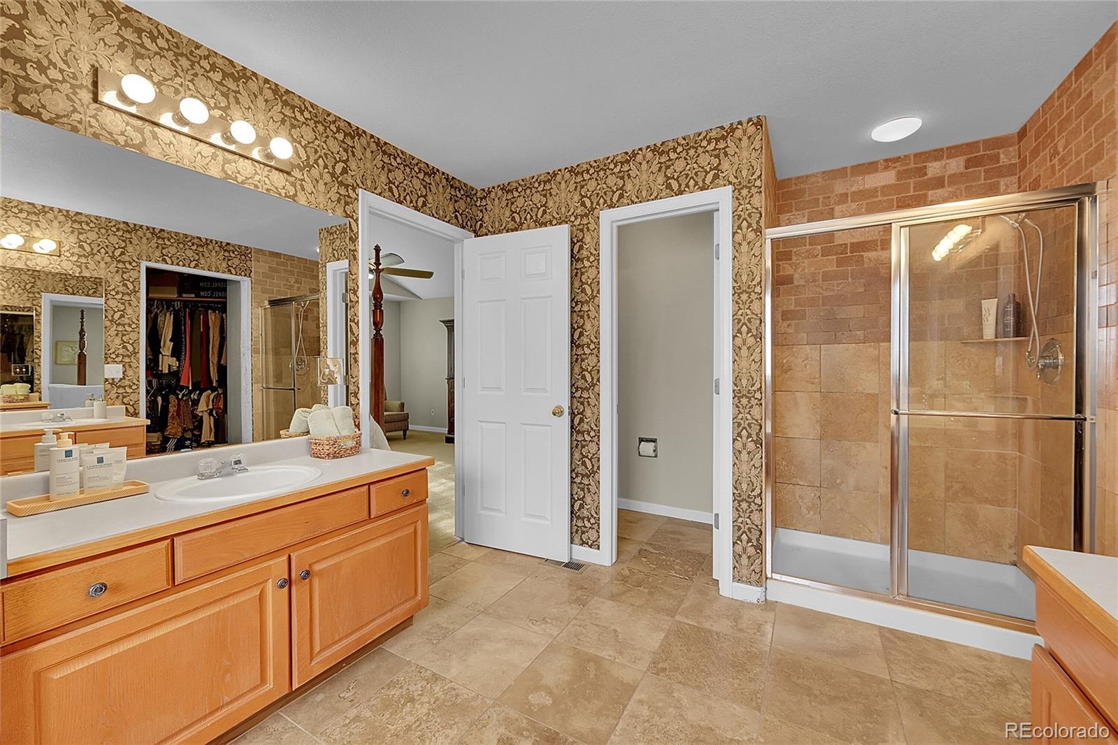 9424 South Hackberry Lane Highlands Ranch, CO 80129 - Photo 24 of 47 a spacious bathroom with a shower sink and mirror