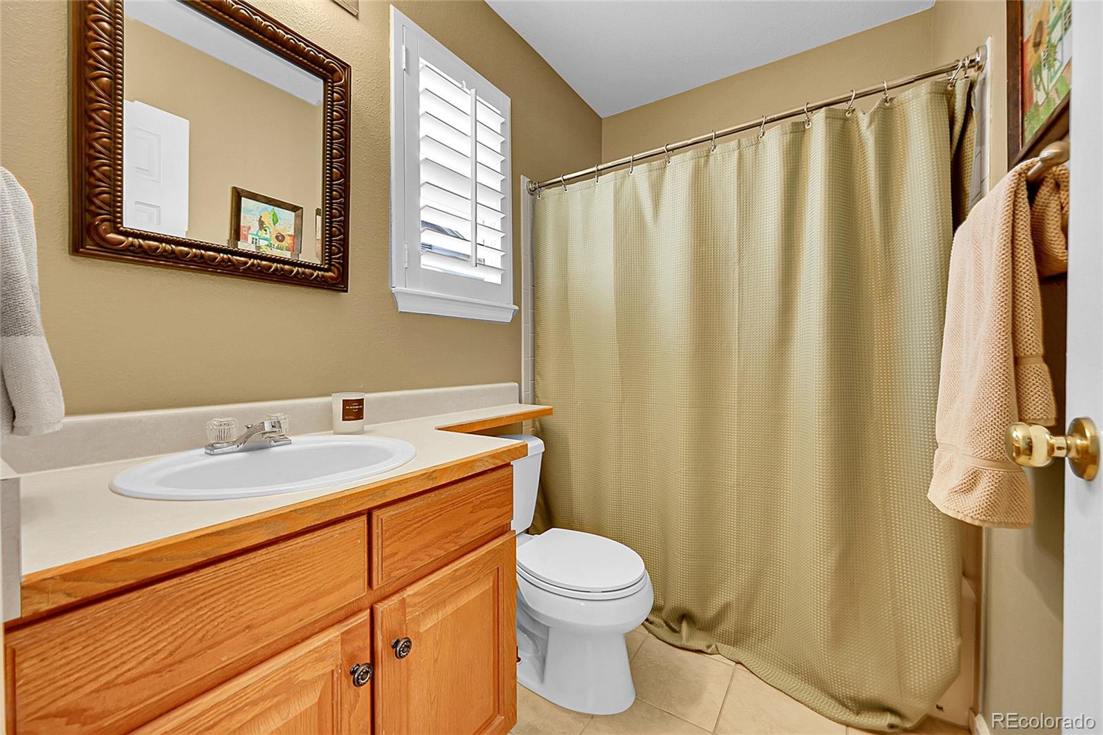 9424 South Hackberry Lane Highlands Ranch, CO 80129 - Photo 31 of 47 a bathroom with a granite countertop sink and a mirror