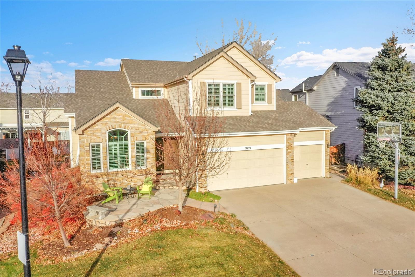 9424 South Hackberry Lane Highlands Ranch, CO 80129 - Photo 45 of 47 a front view of a house with a yard and garage