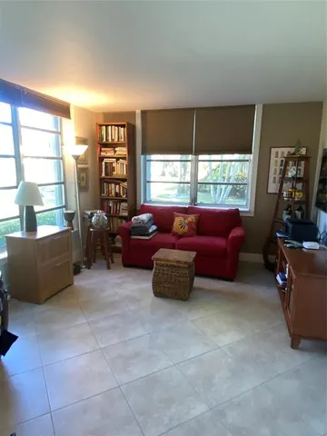 a living room with furniture and a floor to ceiling window
