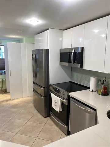 a kitchen with stainless steel appliances granite countertop a refrigerator and a stove