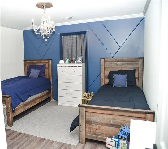 a bedroom with a large bed and chandelier