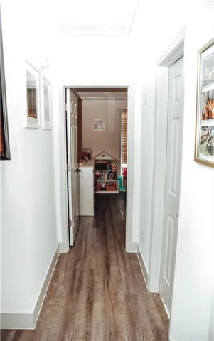 a view of a hallway with wooden floor and a living room