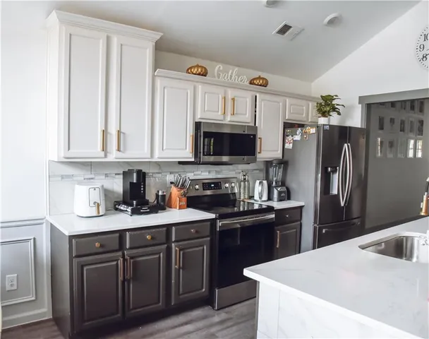 a kitchen with stainless steel appliances granite countertop a refrigerator stove a sink dishwasher and microwave with wooden cabinets