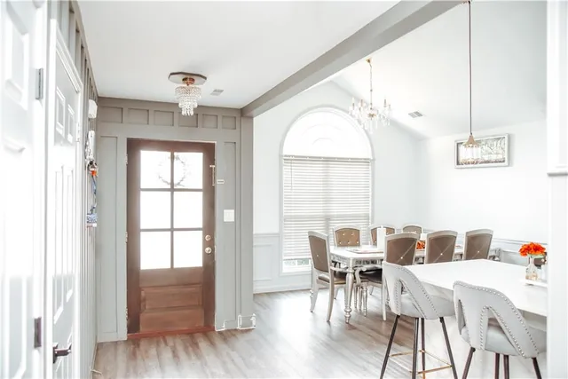 a dining room with furniture a chandelier and wooden floor