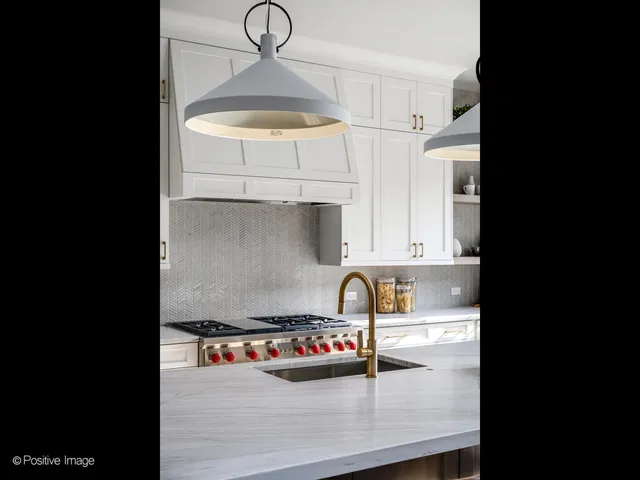 a kitchen with a sink a stove and cabinets