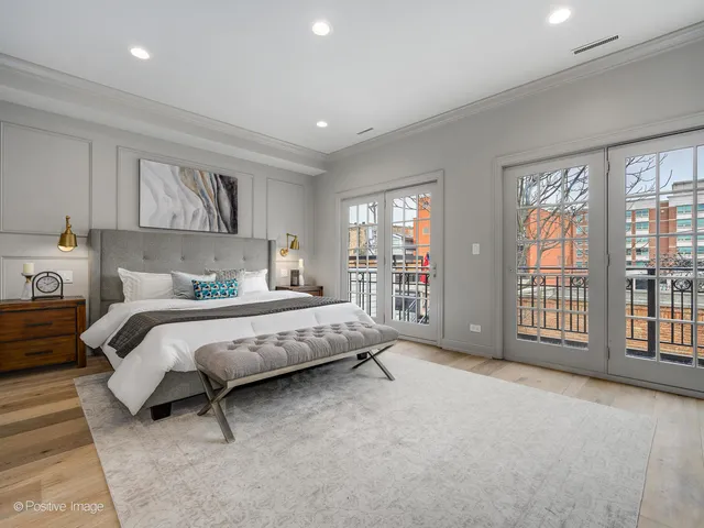 a spacious bedroom with a bed a table and a large window