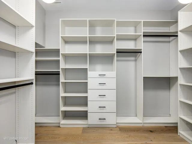 a view of walk in closet with empty racks