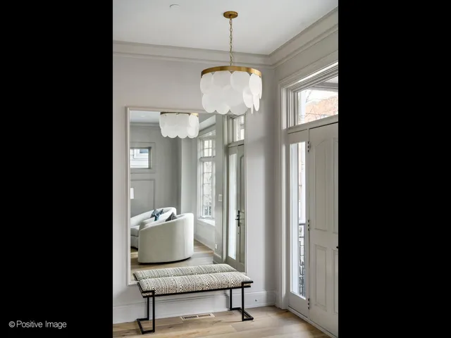 a view of a hallway with a livingroom and a chandelier
