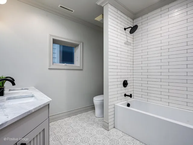 a bathroom with a granite countertop sink a toilet and bathtub