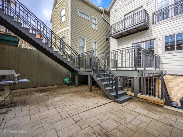 a view of a house with a barbeque and wooden stairs