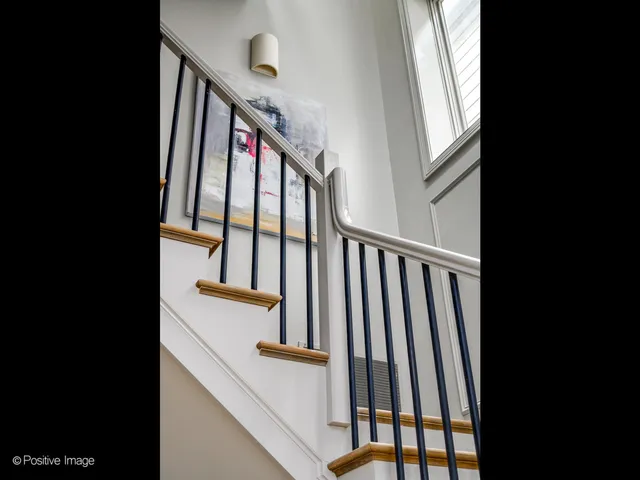 a view of staircase with railing and white walls