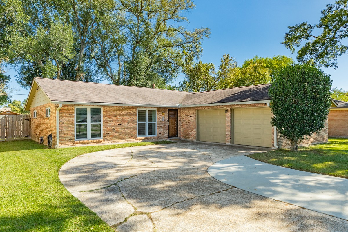a view of a house with a garden and trees