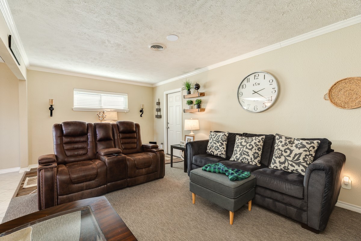 820 Perry Street Angleton, TX 77515 - Photo 13 of 26 a living room with furniture a clock on wall and a window
