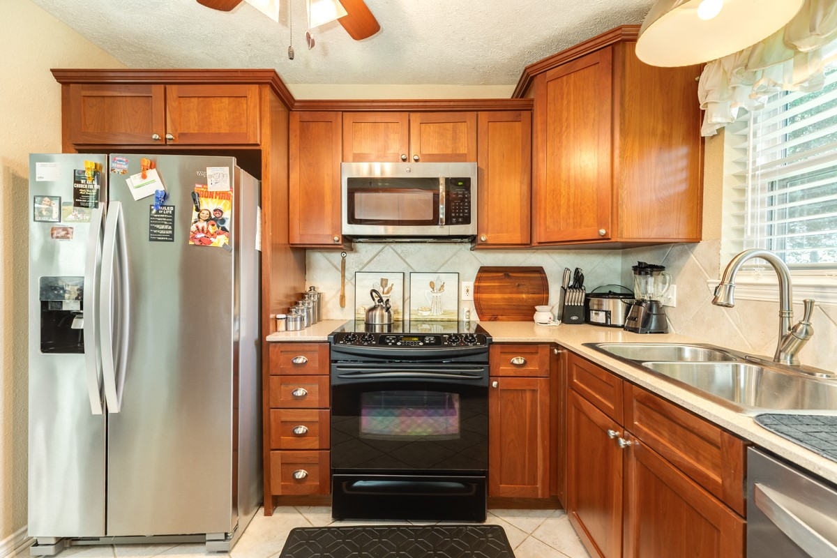 820 Perry Street Angleton, TX 77515 - Photo 18 of 26 a kitchen with granite countertop a refrigerator stove and sink