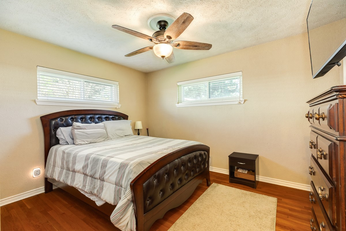 820 Perry Street Angleton, TX 77515 - Photo 24 of 26 a bedroom with a bed and a chandelier