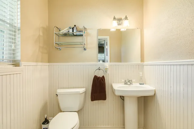 a bathroom with a sink and mirror with toilet