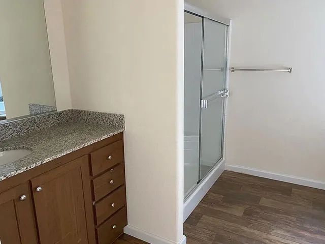 a bathroom with a granite countertop sink and a mirror