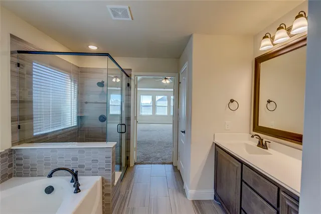 a bathroom with a tub a sink and mirror