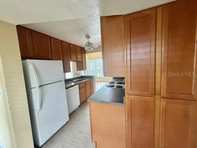 a kitchen with refrigerator a microwave a sink and cabinets