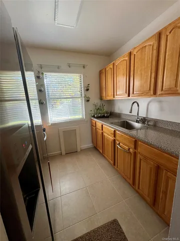 a kitchen with granite countertop a sink a stove and cabinets