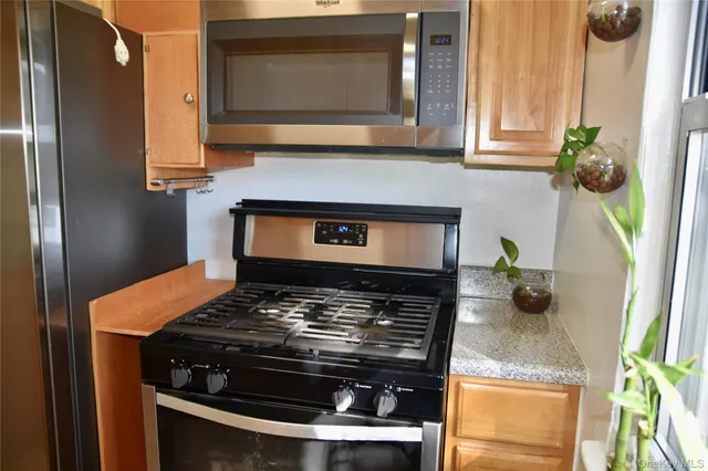 a kitchen with stainless steel appliances granite countertop a stove and a microwave