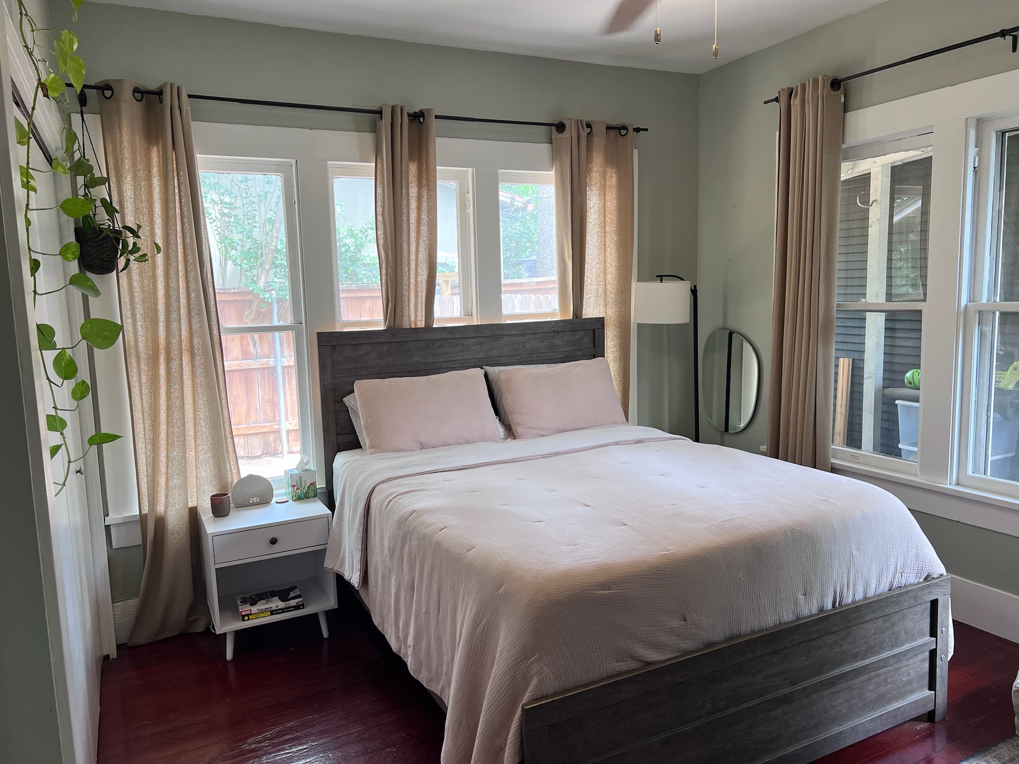 307 East 35th Street, Unit A Austin, TX 78705 - Photo 15 of 31 Natural light floods this charming bedroom, highlighting its warm wood flooring and inviting atmosphere.