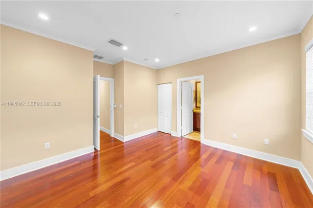 a view of an empty room with wooden floor