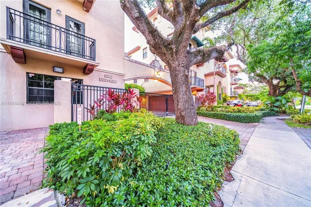 a front view of a multi story residential apartment building with yard and sign board