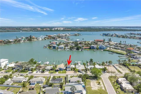 an aerial view of ocean and residential houses with outdoor space