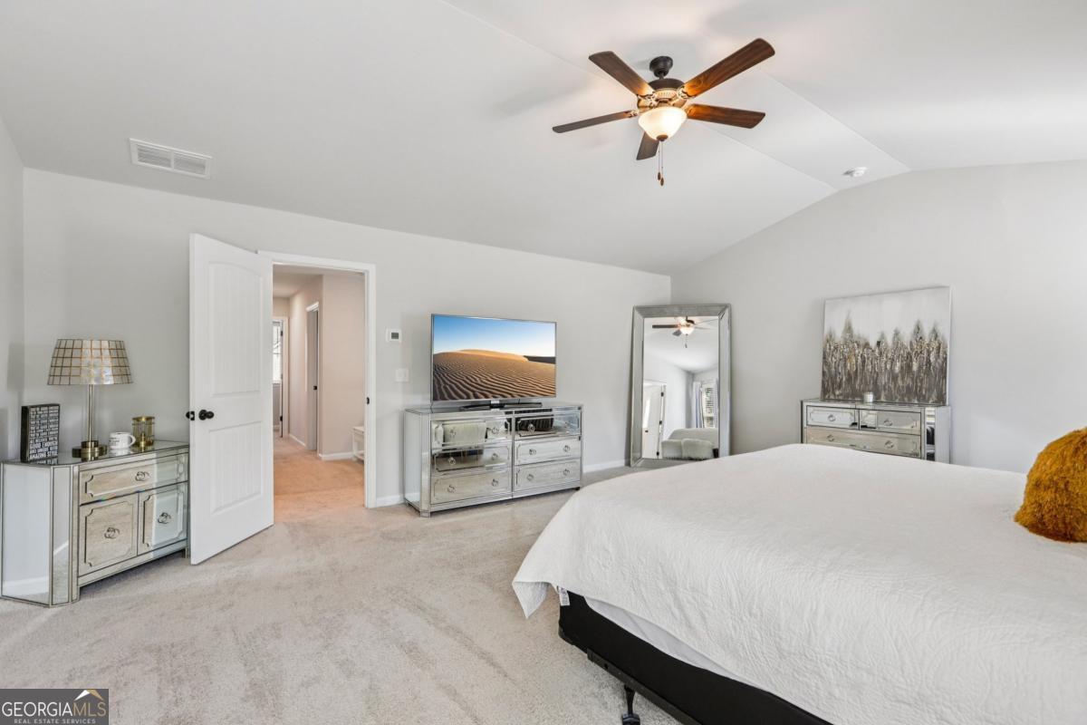 4774 Sultana Way Atlanta, GA 30331 - Photo 20 of 25 a spacious bedroom with a bed a dresser and a chandelier