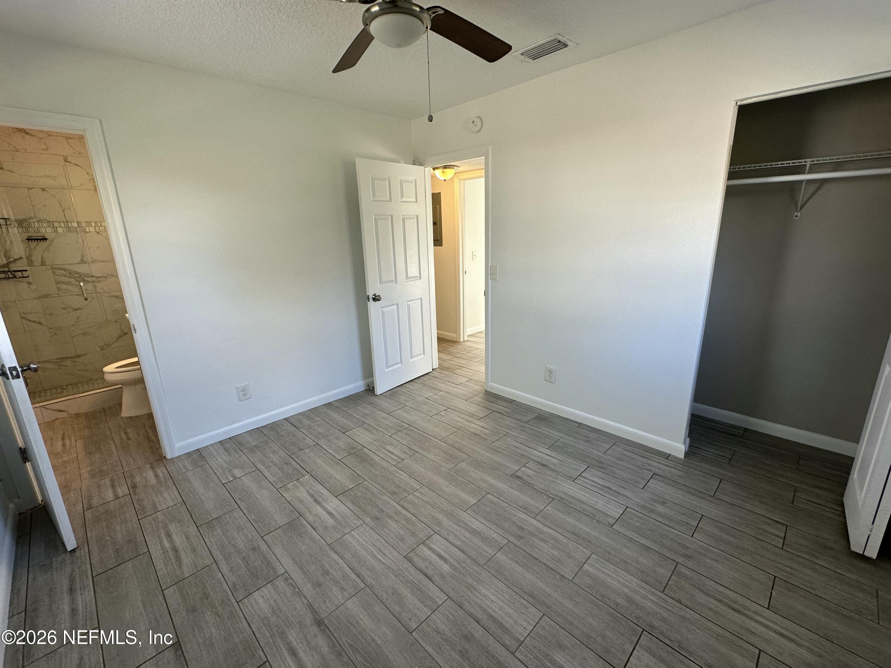 365 Sargo Road Atlantic Beach, FL 32233 - Photo 17 of 23 an empty room with wooden floor a ceiling fan and kitchen space
