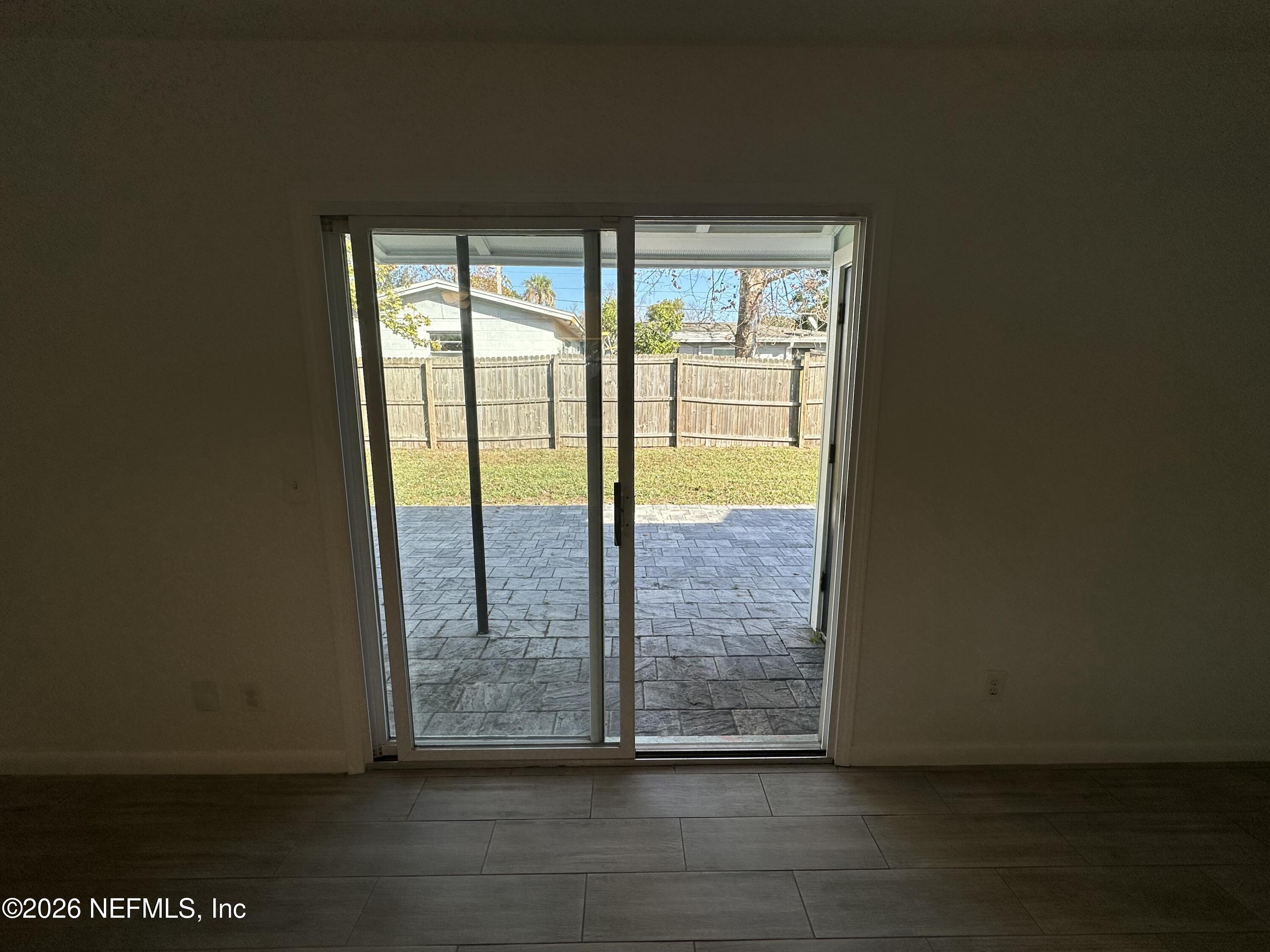 365 Sargo Road Atlantic Beach, FL 32233 - Photo 19 of 23 a view of an empty room with wooden floor and a floor to ceiling window