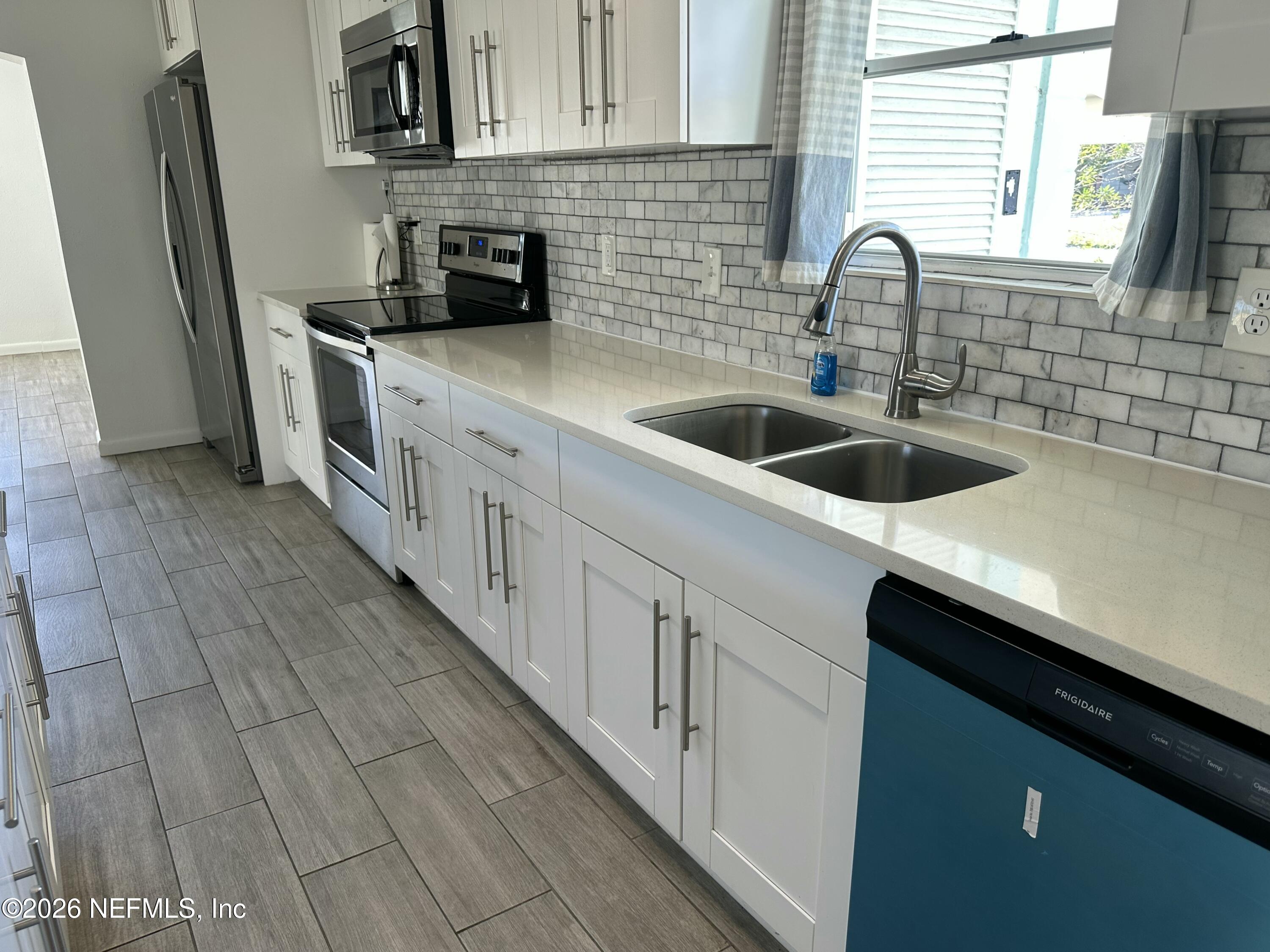 365 Sargo Road Atlantic Beach, FL 32233 - Photo 4 of 23 a kitchen with stainless steel appliances a sink stove and cabinets