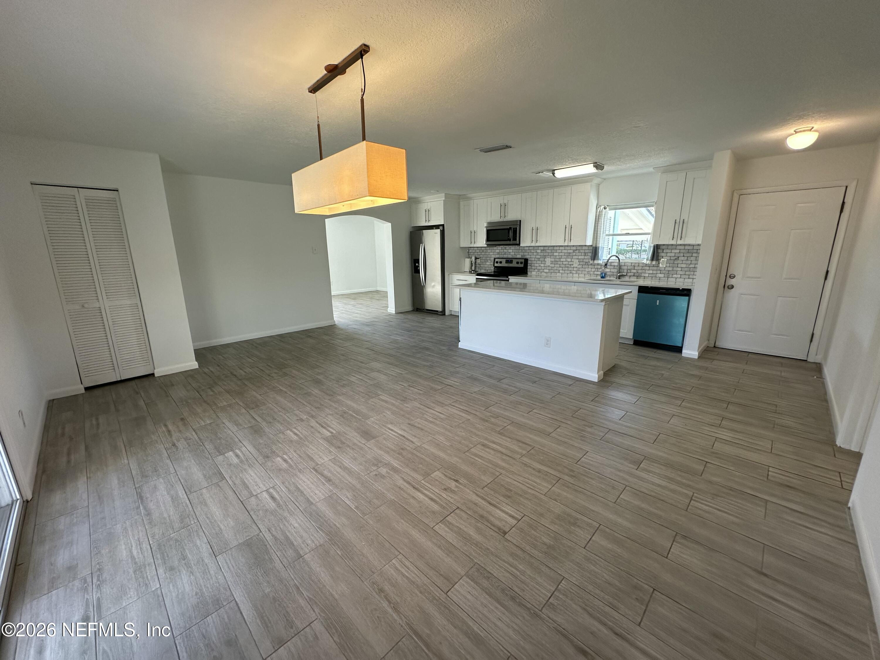 365 Sargo Road Atlantic Beach, FL 32233 - Photo 5 of 23 a view of kitchen with granite countertop wooden floors stainless steel appliances and a sink