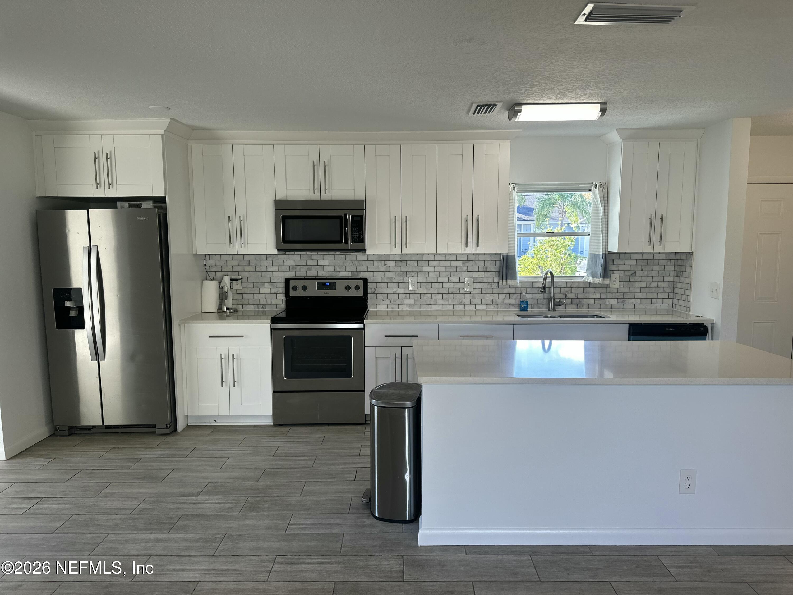 365 Sargo Road Atlantic Beach, FL 32233 - Photo 6 of 23 a kitchen with stainless steel appliances granite countertop a stove a sink and a refrigerator